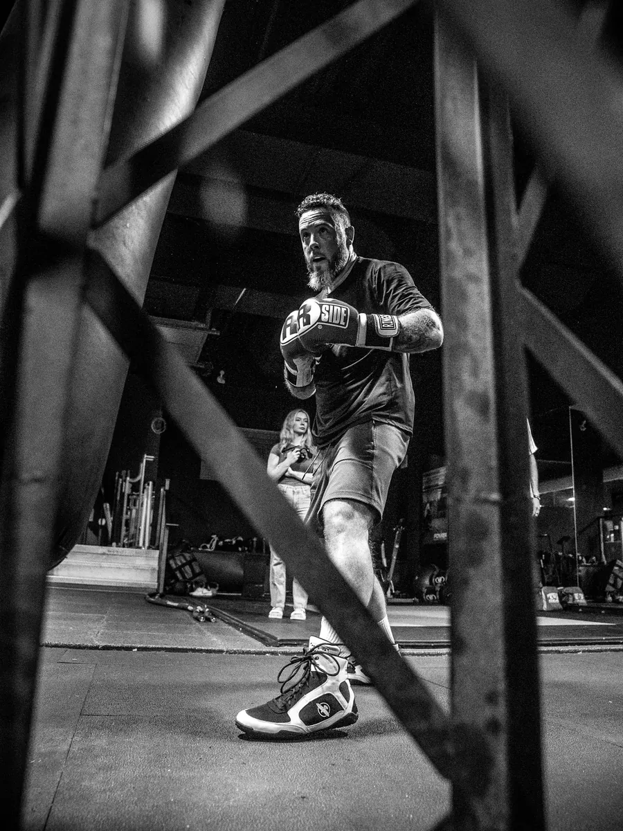 Boxer working the floor, framed through the ring ropes