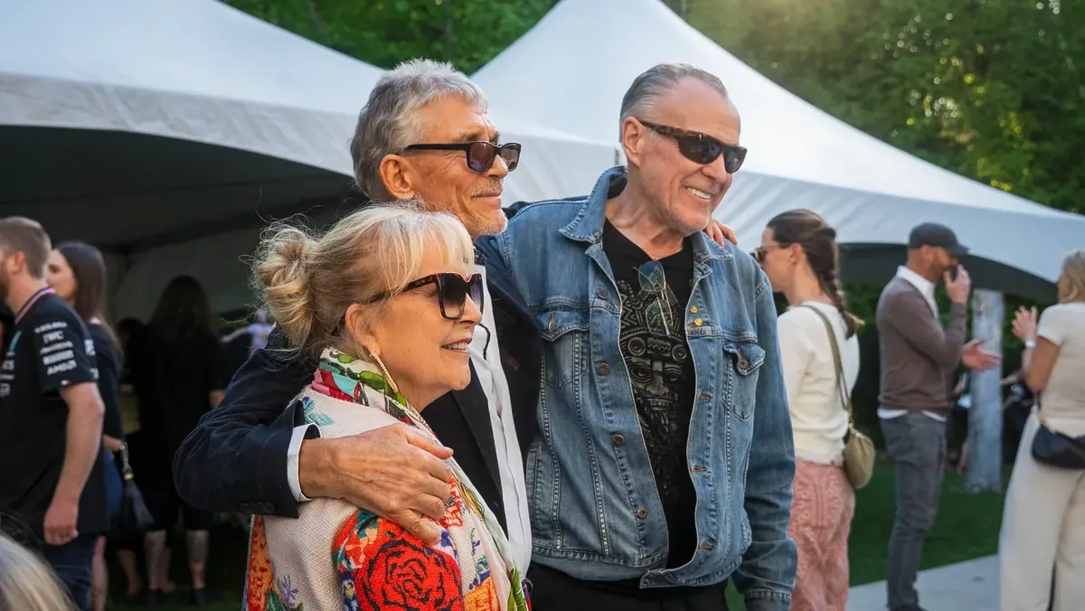 Guests laughing together in front of white marquee tents at a garden party