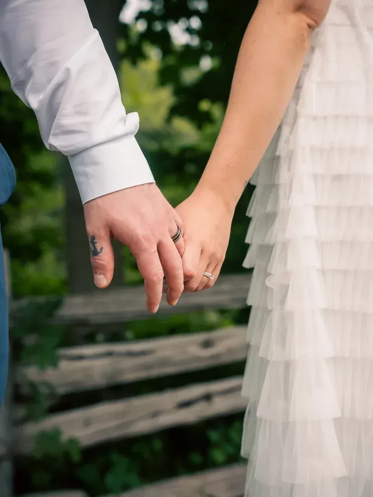 Bride and groom holding hands, her tulle dress filling the frame